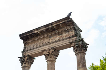Closed Up to a Three ancient pillars into a Central Cemetery in downton bogota, with a pidgeon over the pillars.の写真素材