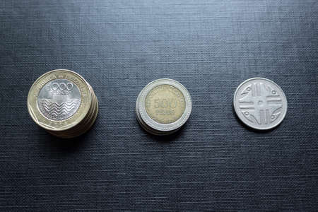 Closeup to a pile of Colombian coins over black background. Ideal for economy, money, banks, save money and finance.の写真素材