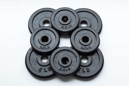 Closeup to a dumbbell disc over white background. Ideal for fitness, sports, and healthy life.の写真素材