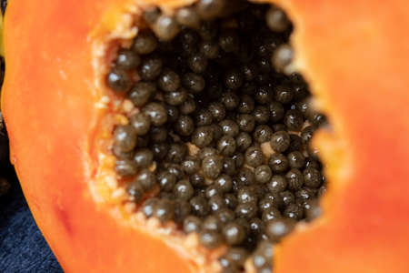 Macro photography to asliced orange fresh papaya with seeds inside. Fruit and texture conceptの写真素材