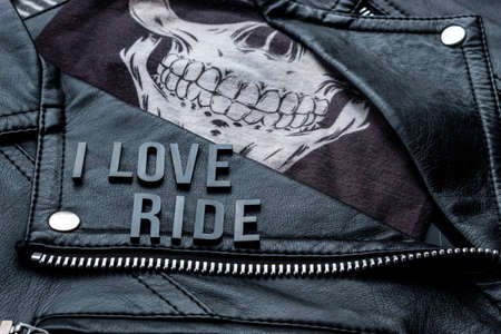 closeup to I love ride lettering over biker leather jacket and skull kerchief. motorcycle styleの写真素材