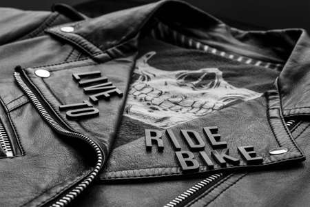 closeup to live to ride bike lettering over biker leather jacket and skull kerchief. motorcycle style, black and white photographyの写真素材