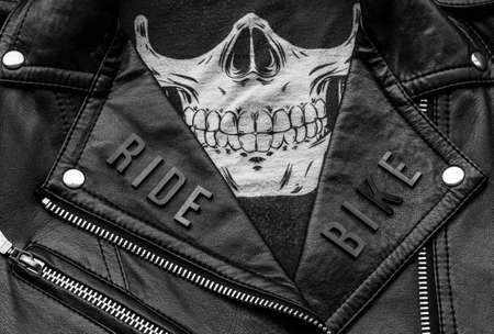closeup to ride bike lettering over biker leather jacket and skull kerchief. motorcycle style, black and white photographyの写真素材