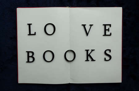 Close up to LOVE BOOKS lettering over blank notebook at blue navy background. Reading and study concept photographyの写真素材