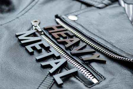 Closeup to a HEAVY METAL black lettering word over a black biker leather jacket. Heavy metal music lovers and fashion concept styleの写真素材