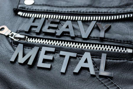 Closeup to a HEAVY METAL black lettering word over a black biker leather jacket. Heavy metal music lovers and fashion concept styleの写真素材