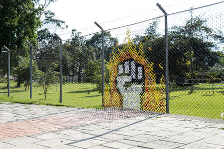 A Closed Fist Streetart formed with clothes into a metal grid at Bogotáのeditorial素材