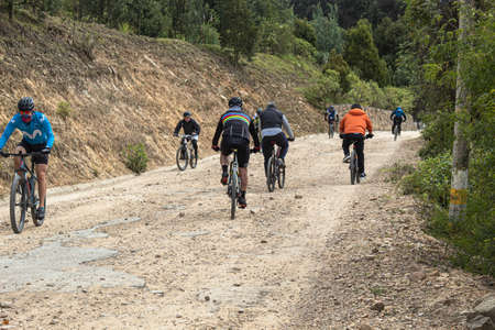 People riding mountain bicycle over a sand path road at bogota mountains during permitted exercice in coronavirus quarantine.のeditorial素材