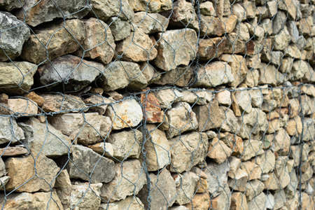 Metal grid with rock or stone wall wallpaper. ideal for textures and backgrounds. construction conceptの写真素材