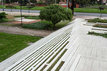 Geometric pattern of a modern street stairways with green gardens, trees and nature architecture. A highway at backgroundの写真素材