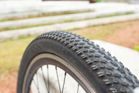 Close up to a black bike tire pattern and blurred green garden at backgroundの写真素材