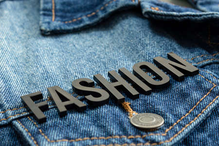 Closeup to a fashion lettering black word over a gradient Blue jean jacket. Fashion concept