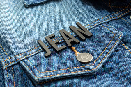 Closeup to a JEAN lettering black word over a gradient Blue jean jacket. Fashion conceptの写真素材