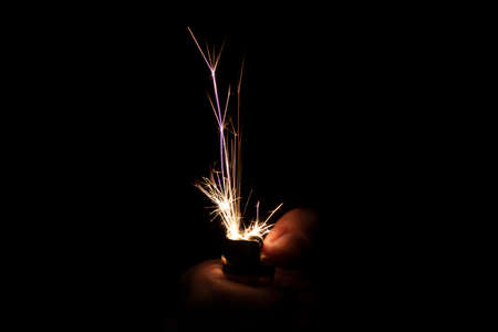 Closeup to hand igniting fire lighters with black background. Energy and light conceptの写真素材