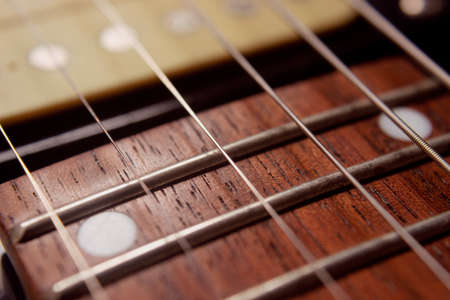 Macro photography to a six electric guitar strings and wooden fretboards. Vintage instruments and...