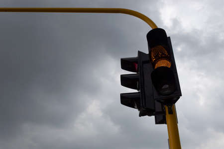 Yellow Traffic light with gray and rainy day at background. Traffic concept