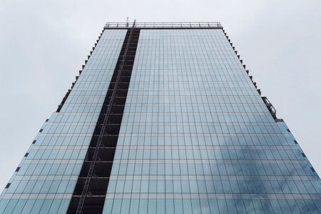 BOGOTA, COLOMBIA - Low Angle view of a Blue window modern skyscraper under construction reflecting blue cloudy sky at sunny dayのeditorial素材