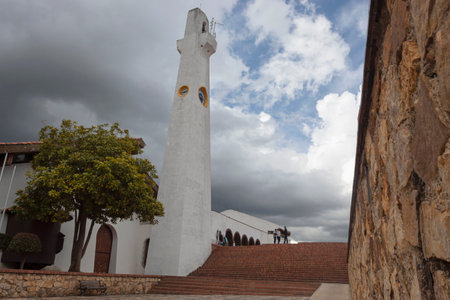 Colombian Guatavita town main square view with church stairs and clocktower at cloudy dayの写真素材