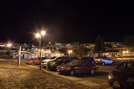 GUATAVITA, COLOMBIA - Public parking at downtown with city lights into mountain at background, night photograhpyのeditorial素材