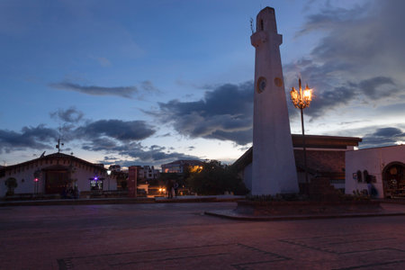 GUATAVITA, COLOMBIA - beautiful scene of a Clock tower square with a pale yellow lights and blue sky at eveningのeditorial素材