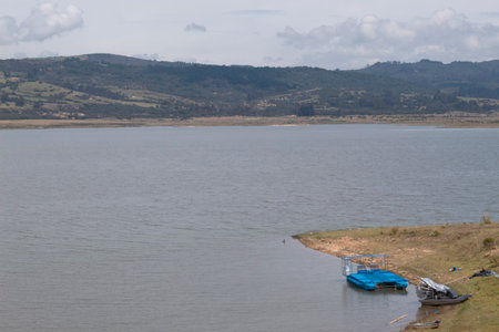 GUATAVITA, COLOMBIA - Tomine Lake at sunny morning with mountains and gray skyの写真素材