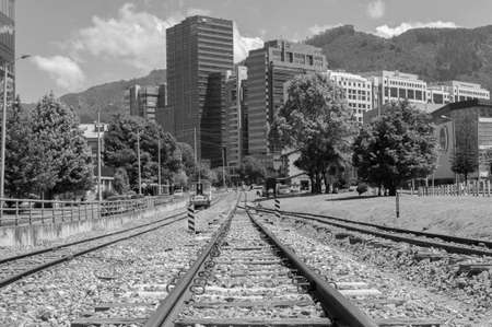 BOGOTA, COLOMBIA - FEBRUARY 10 OF 2021 A summer scene of Bogota Usaquen Train station with modern buildings at background and oriental mountains. Black and white photographyのeditorial素材