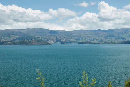 Beautiful summer scene of Blue Colombian Tota lake located in Boyaca, with andes mountains and cloudy blue sky at middayの写真素材