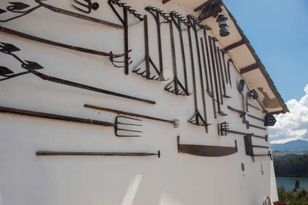 Old farmer tools hangin of wall of antique house in colombian old townのeditorial素材