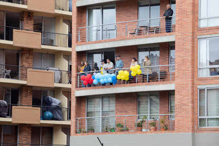 BOGOTA, COLOMBIA - JULY 20 OF 2022 Neighbors watching the military independence day parade from a balcony of a buildingのeditorial素材