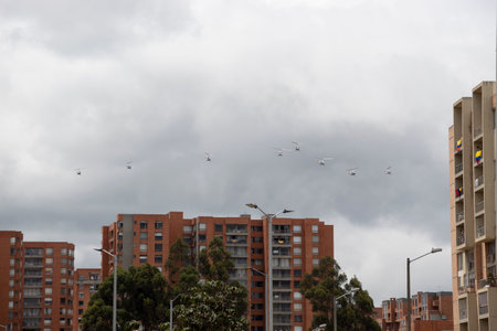 BOGOTA, COLOMBIA - JULY 20 OF 2022 Eight Helicopters unit flying over residential buildings during colombian independence day armed forces parade with gray sky at backgroundのeditorial素材
