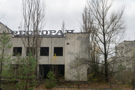 An abandoned big shop at dowton pripyat city with high branched trees and cloudy sky in backgroundのeditorial素材
