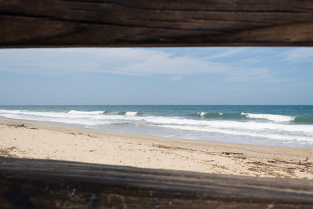 Caribbean beach viewed through a wooden rectangles in sunny dayの写真素材