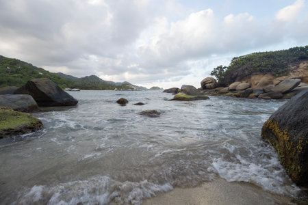 Beautiful dusk scene of rocky mossy beach in colombia tayrona parkの写真素材
