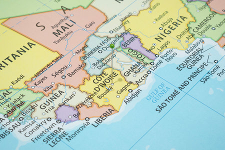 Close up to a Bouake city with a green pin needle into Ivory Coast country political mapの写真素材