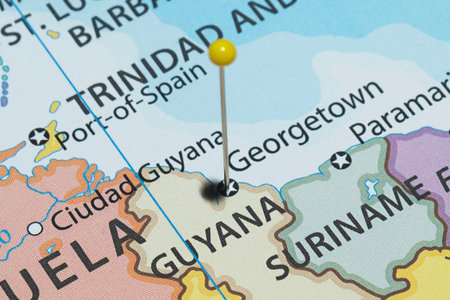Close up to a Georgetown city with a yellow pin needle into Guyana country political map