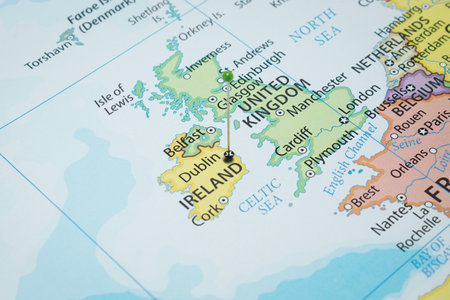 Close up to a Dublin city with a green pin needle into Ireland country political mapの写真素材