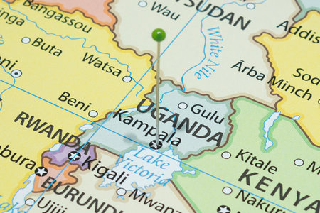 Macro photo of Kampala with a green pin needle into Uganda country political mapの写真素材