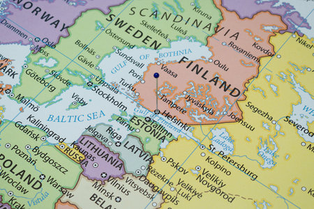 Close up to a Helsinki city with a blue pin needle into Finland country political mapの写真素材