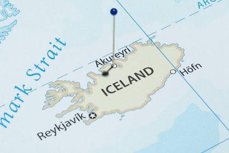 Close up to an Akureyri city with a blue pin needle into Iceland country political mapの写真素材