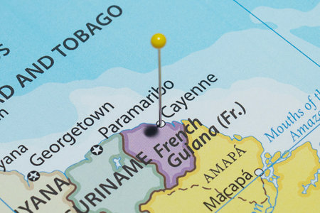 Close up to a Cayenne city with a yellow pin needle into French Guiana country political mapの写真素材