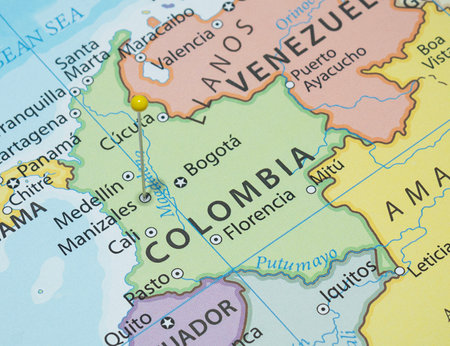 Close up to a Manizales city with a Yellow pin needle into Colombia country political mapの写真素材