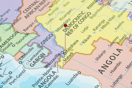 Close up to a Kinshasa city with a red pin needle into Democratic Republic of the Congo country political mapの写真素材