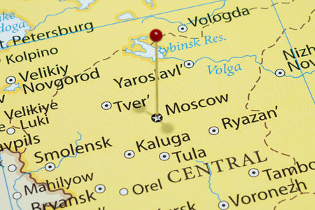 Macro photo of Moscow city with a red pin needle into Russia country political map