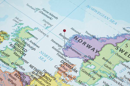 Close up to a Stavanger city with a red pin needle into Norway country political mapの写真素材