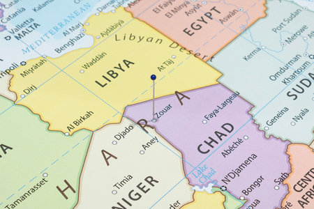 Close up to a Zouar city with a blue pin needle into Chad country political mapの写真素材