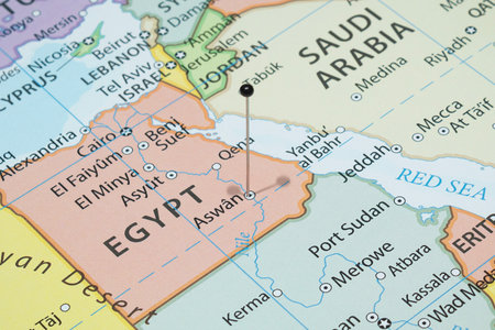 Close up to an Aswan city with a black pin needle into Egypt country political map