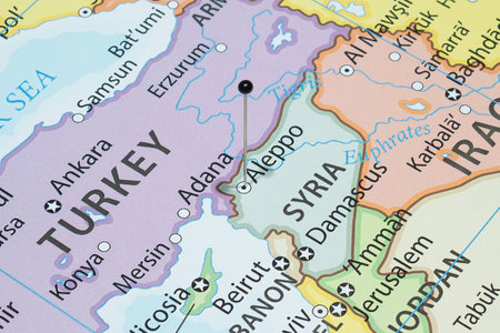 Close up to a Aleppo city with a black pin needle into Syria country political mapの写真素材