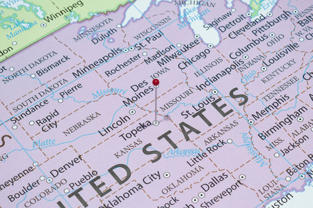 Close up to a Topeka city with a red pin needle into United States of America country political map