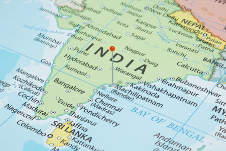 Close up to a city with an orange pin needle into India country political mapの写真素材