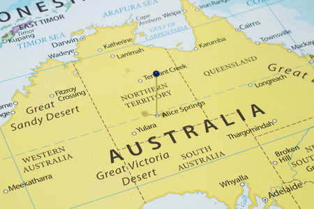 Close up to an Alice Springs city with a blue pin needle into Australia country political mapの写真素材